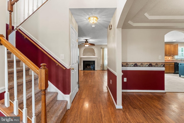 135 Hobbs Hole Ln, Tappahannock, VA 22560 - foyer entrance with arched walkways, a ceiling fan, wood finished floors, a fireplace, and a textured ceiling