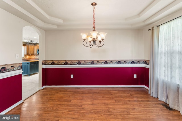 135 Hobbs Hole Ln, Tappahannock, VA 22560 - spare room with a raised ceiling, a chandelier, wood finished floors, and arched walkways