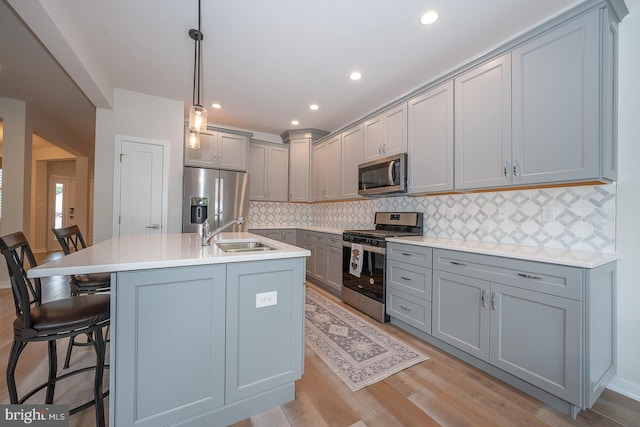 726 Switchman Rd, Media, PA 19063 - kitchen featuring appliances with stainless steel finishes, gray cabinetry, a breakfast bar, decorative backsplash, and recessed lighting