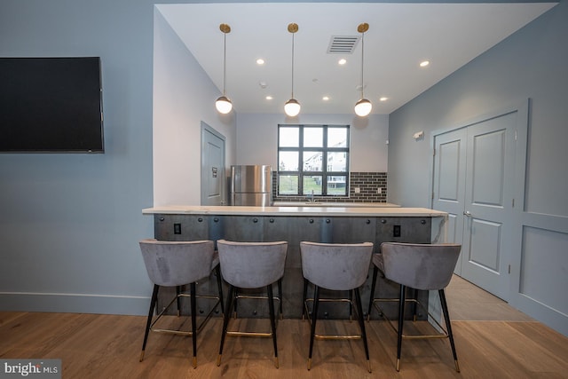 726 Switchman Rd, Media, PA 19063 - kitchen featuring freestanding refrigerator, a kitchen bar, decorative backsplash, wood finished floors, and recessed lighting