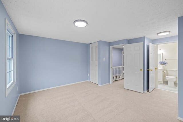 8318 Brookvale Ct, Springfield, VA 22153 - unfurnished bedroom featuring carpet flooring, a textured ceiling, and connected bathroom