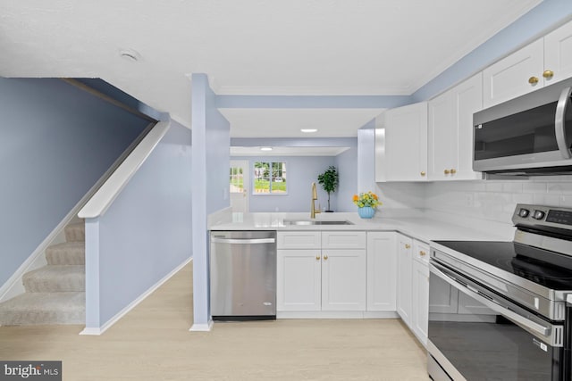 8318 Brookvale Ct, Springfield, VA 22153 - kitchen with stainless steel appliances, light countertops, white cabinets, light wood-style floors, and tasteful backsplash
