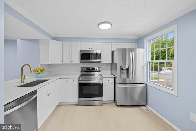 8318 Brookvale Ct, Springfield, VA 22153 - kitchen featuring stainless steel appliances, light wood-style flooring, light countertops, a textured ceiling, and white cabinetry
