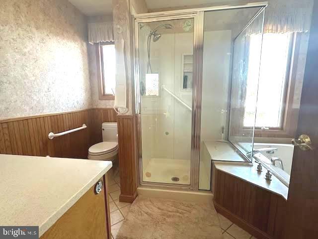 32 Saranac Rd, Hamilton, NJ 08619 - bathroom featuring a stall shower, tile patterned flooring, vanity, a garden tub, and a wainscoted wall