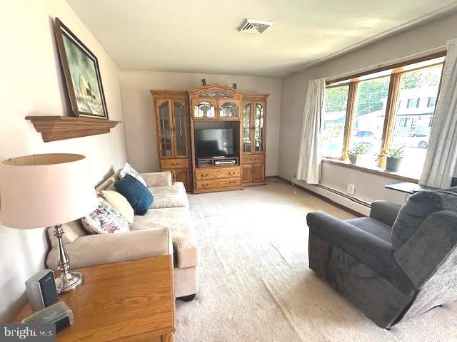 32 Saranac Rd, Hamilton, NJ 08619 - living room featuring a baseboard heating unit and light carpet