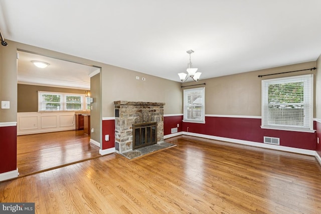 5 Brookfield Rd, Pasadena, MD 21122 - unfurnished living room with wood finished floors, a chandelier, and a fireplace
