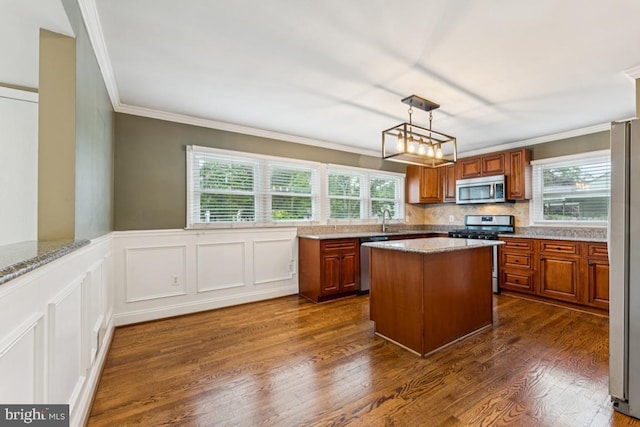 5 Brookfield Rd, Pasadena, MD 21122 - kitchen with appliances with stainless steel finishes, crown molding, brown cabinets, healthy amount of natural light, and a wainscoted wall