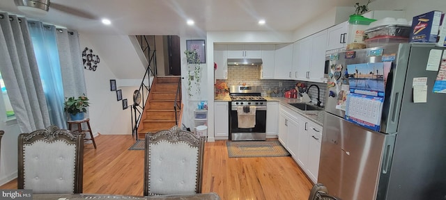 867 Wedgewood Dr, Lansdale, PA 19446 - kitchen with appliances with stainless steel finishes, under cabinet range hood, light wood-style floors, white cabinets, and tasteful backsplash