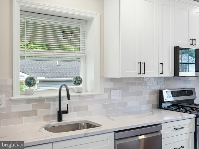 105 Bette Rd, Wilmington, DE 19803 - kitchen featuring appliances with stainless steel finishes, white cabinetry, backsplash, and light stone counters