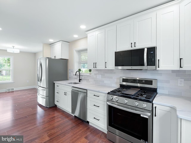 105 Bette Rd, Wilmington, DE 19803 - kitchen featuring stainless steel appliances, dark wood-type flooring, light stone countertops, white cabinetry, and backsplash