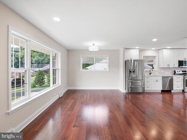 105 Bette Rd, Wilmington, DE 19803 - kitchen with stainless steel appliances, light countertops, dark wood-style flooring, decorative backsplash, and white cabinetry