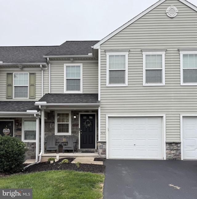 345 Cedar Run Dr, York, PA 17404 - view of property with stone siding, driveway, a garage, a porch, and roof with shingles