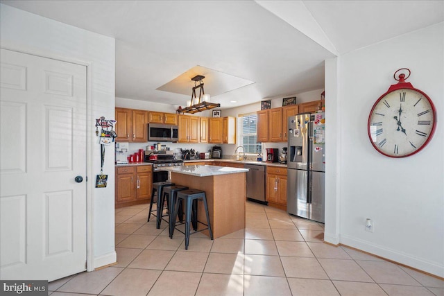 8255 Longpoint Rd, Baltimore, MD 21222 - kitchen with appliances with stainless steel finishes, a center island, a breakfast bar, light tile patterned floors, and brown cabinets