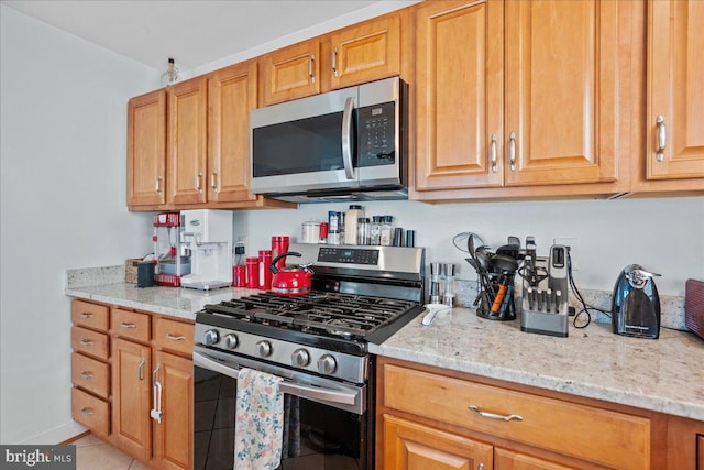 8255 Longpoint Rd, Baltimore, MD 21222 - kitchen with stainless steel appliances, light stone countertops, light tile patterned floors, and brown cabinetry