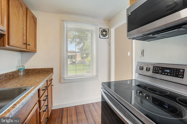 2301 Airacobra St, Levittown, PA 19057 - kitchen with appliances with stainless steel finishes, dark wood-style flooring, and brown cabinets