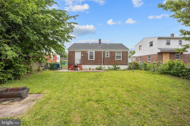 2301 Airacobra St, Levittown, PA 19057 - rear view of house with brick siding, a patio area, and a chimney