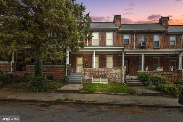 2017 Ruxton Ave, Baltimore, MD 21216 - townhome / multi-family property with brick siding, cooling unit, and covered porch
