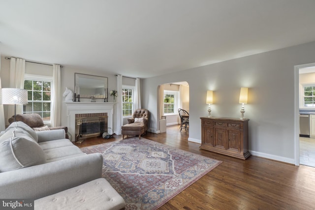 1931 Edgewood Rd, Towson, MD 21286 - living area with arched walkways, plenty of natural light, wood finished floors, and a brick fireplace