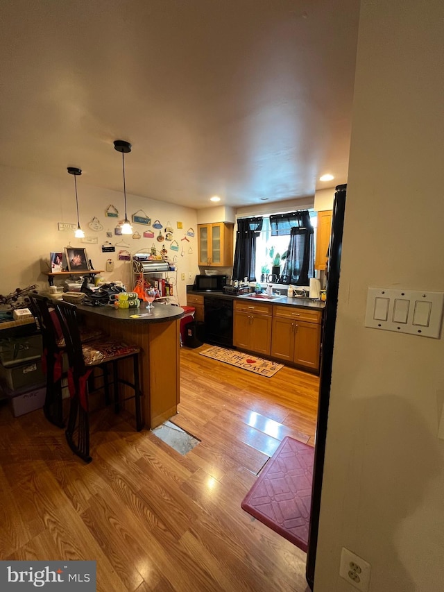 129 Laureba Ave, Stratford, NJ 08084 - kitchen featuring black appliances, light wood-type flooring, dark countertops, a peninsula, and glass insert cabinets