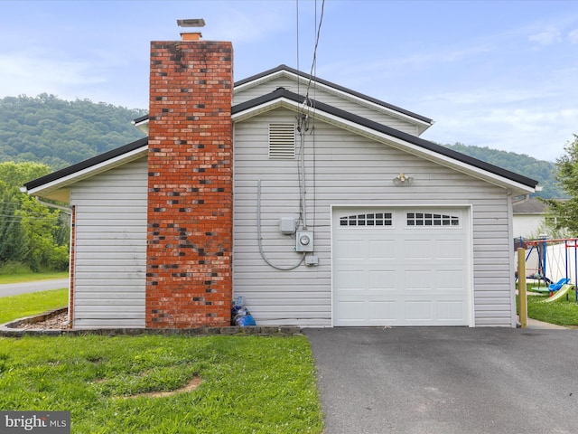 15 Nightingale St, Keyser, WV 26726 - view of side of home with a chimney, asphalt driveway, a yard, and an attached garage