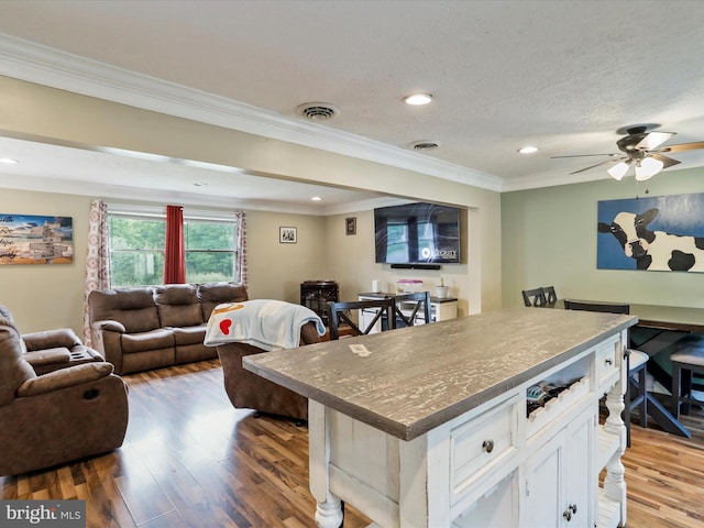 15 Nightingale St, Keyser, WV 26726 - kitchen with open floor plan, a kitchen island, crown molding, white cabinets, and wood finished floors