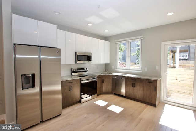 2417 N Hancock St, Philadelphia, PA 19133 - kitchen with appliances with stainless steel finishes, light wood-style flooring, white cabinets, recessed lighting, and decorative backsplash