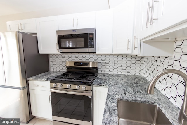 10040 Jeanes St, Philadelphia, PA 19116 - kitchen with appliances with stainless steel finishes, light stone counters, white cabinetry, and tasteful backsplash