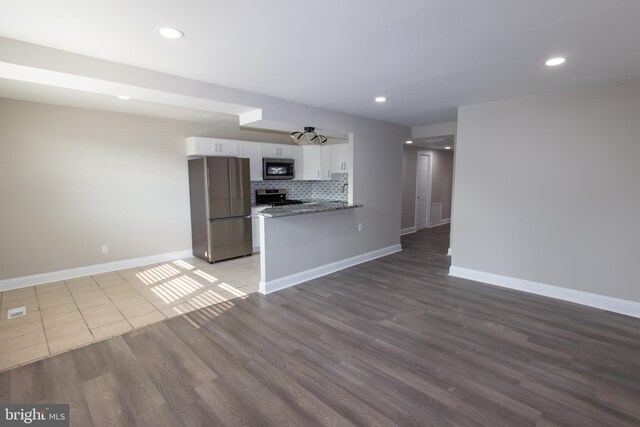 10040 Jeanes St, Philadelphia, PA 19116 - kitchen featuring stainless steel appliances, white cabinetry, wood finished floors, decorative backsplash, and open floor plan