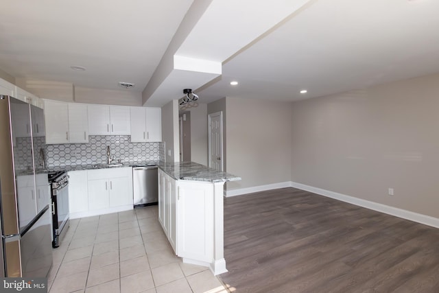 10040 Jeanes St, Philadelphia, PA 19116 - kitchen featuring stainless steel appliances, white cabinets, decorative backsplash, stone counters, and recessed lighting