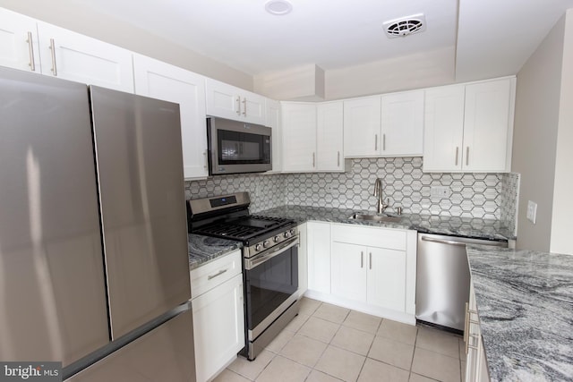 10040 Jeanes St, Philadelphia, PA 19116 - kitchen featuring appliances with stainless steel finishes, light tile patterned floors, stone countertops, and tasteful backsplash