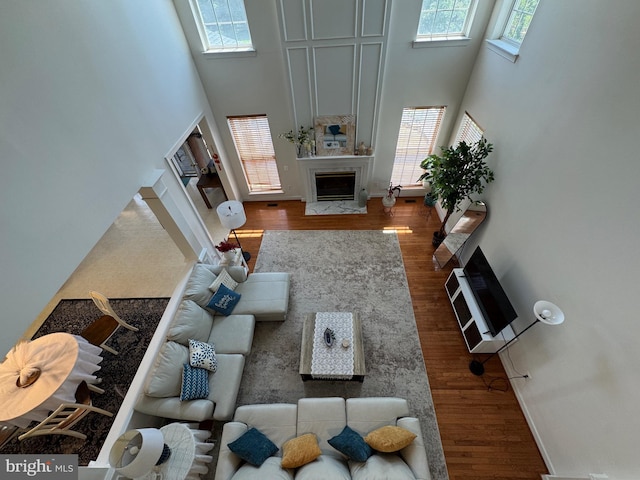 7904 Windsor Knoll Ln, Laytonsville, MD 20882 - living room with a fireplace with flush hearth, a towering ceiling, plenty of natural light, and wood finished floors