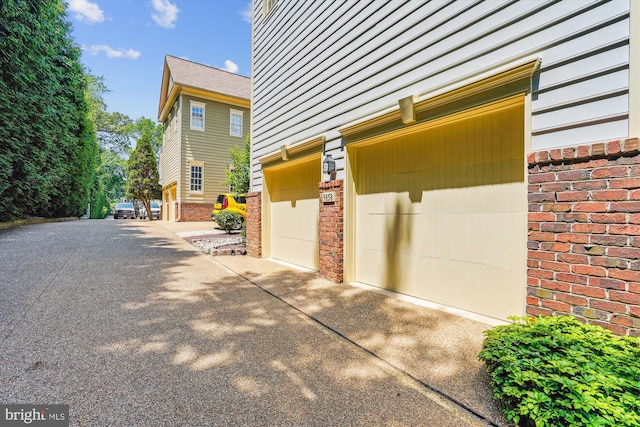 9858 Palace Green Way, Vienna, VA 22181 - view of side of home featuring brick siding, driveway, and an attached garage