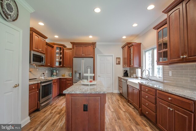 26294 Evesboro Ln, Eden, MD 21822 - kitchen featuring appliances with stainless steel finishes, ornamental molding, tasteful backsplash, light wood-style flooring, and a kitchen island