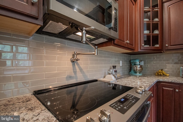 26294 Evesboro Ln, Eden, MD 21822 - kitchen with appliances with stainless steel finishes, decorative backsplash, glass insert cabinets, and light stone countertops