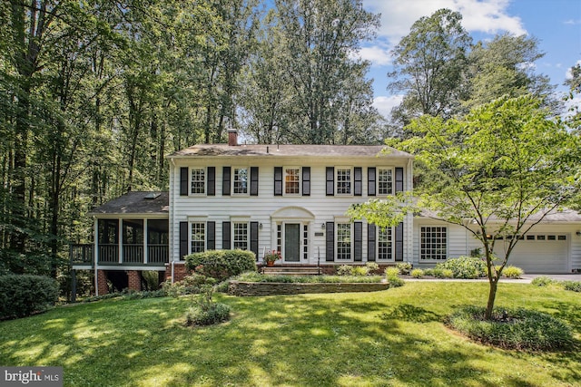 3010 Phyllmar Pl, Oakton, VA 22124 - colonial home featuring a sunroom, a chimney, a front yard, and a garage