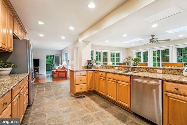 3010 Phyllmar Pl, Oakton, VA 22124 - kitchen featuring appliances with stainless steel finishes, a skylight, healthy amount of natural light, light stone counters, and recessed lighting