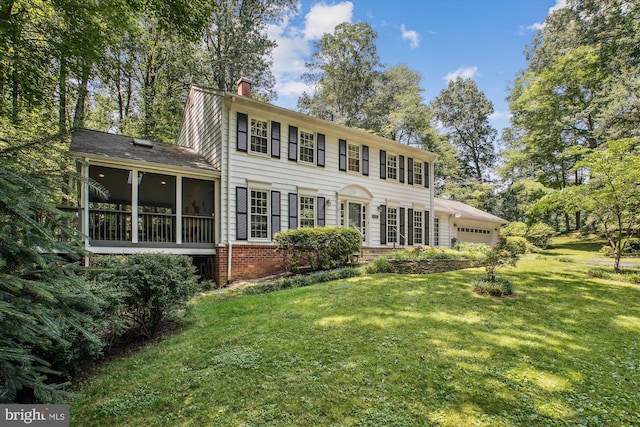 3010 Phyllmar Pl, Oakton, VA 22124 - colonial house with a garage, a chimney, a front lawn, and a sunroom
