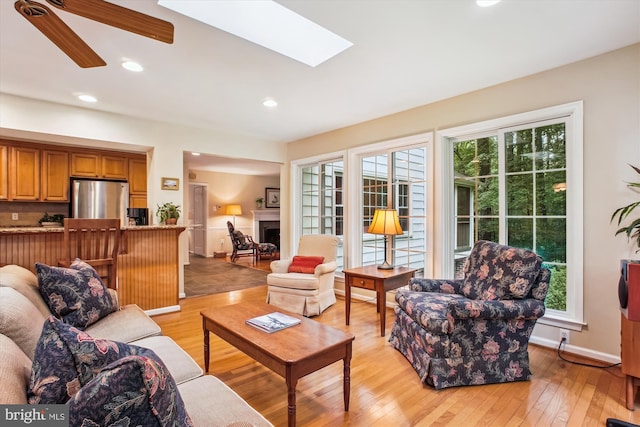 3010 Phyllmar Pl, Oakton, VA 22124 - living area featuring light wood finished floors, a ceiling fan, a fireplace, recessed lighting, and a skylight