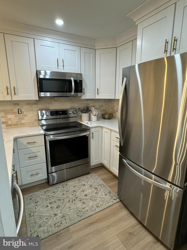 35979 Condo Dr Unit 203B, Rehoboth Beach, DE 19971 - kitchen with appliances with stainless steel finishes, light wood-style floors, light countertops, and backsplash