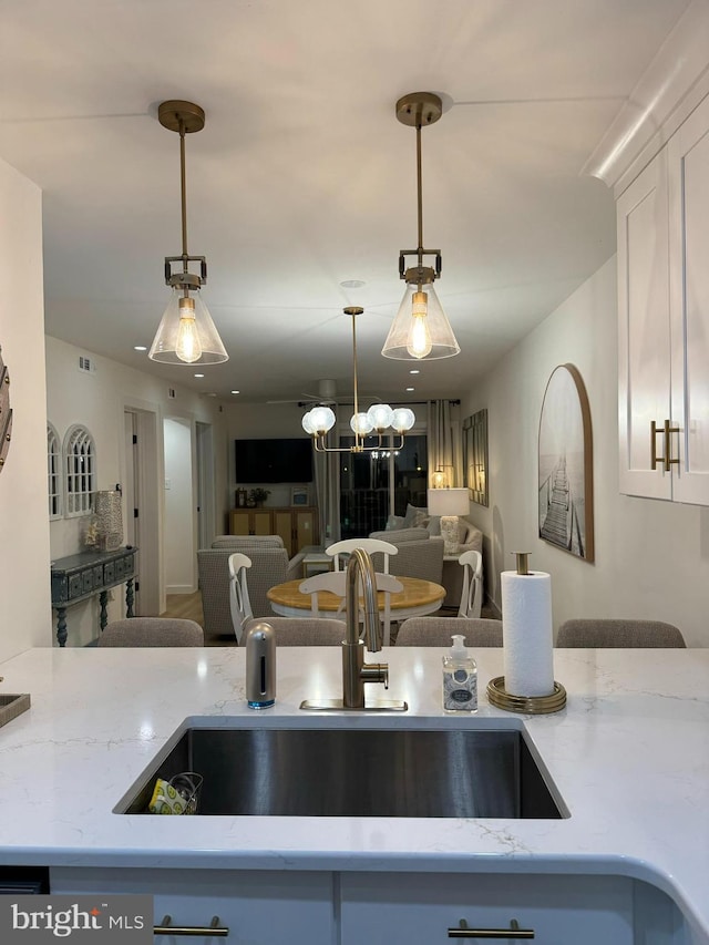 35979 Condo Dr Unit 203B, Rehoboth Beach, DE 19971 - kitchen featuring open floor plan, light stone counters, pendant lighting, and white cabinets