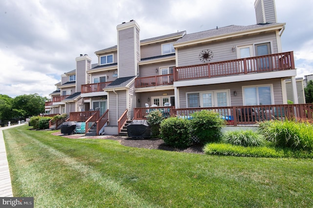101 Main St Unit 115, Secretary, MD 21664 - back of house featuring a balcony, a chimney, a yard, and a wooden deck