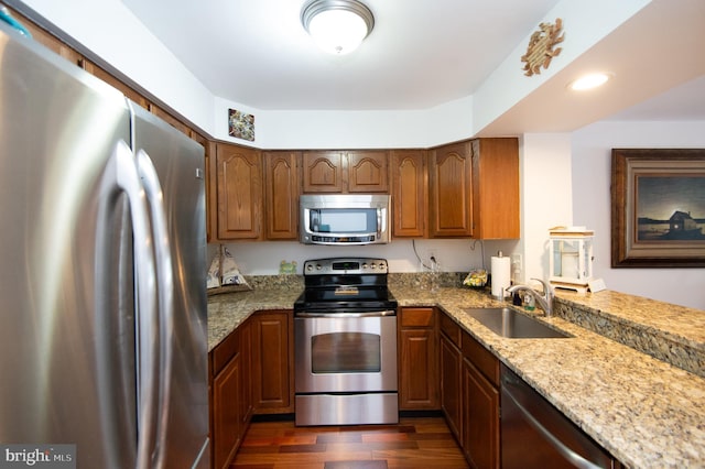 101 Main St Unit 115, Secretary, MD 21664 - kitchen featuring stainless steel appliances, dark wood-style floors, light stone counters, and brown cabinets