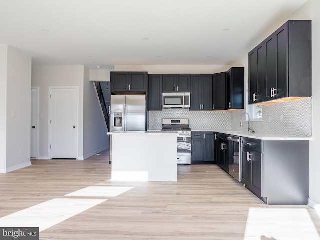 1016 Huntington Ave, Glendora, NJ 08029 - kitchen featuring stainless steel appliances, light wood finished floors, decorative backsplash, light countertops, and dark cabinets
