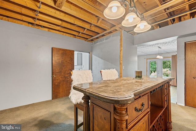 136 Main St, Red Hill, PA 18076 - kitchen with carpet floors, french doors, decorative light fixtures, brown cabinetry, and concrete block wall