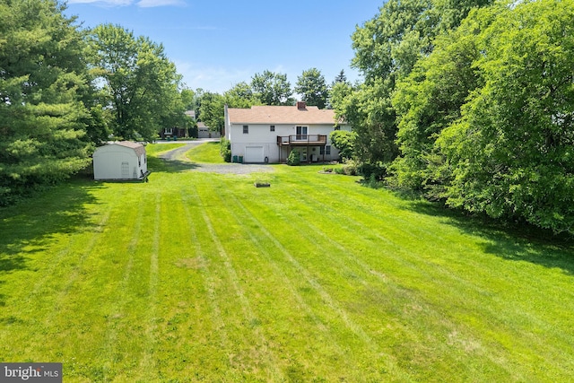 136 Main St, Red Hill, PA 18076 - view of grassy yard featuring a storage shed, a deck, driveway, and an attached garage