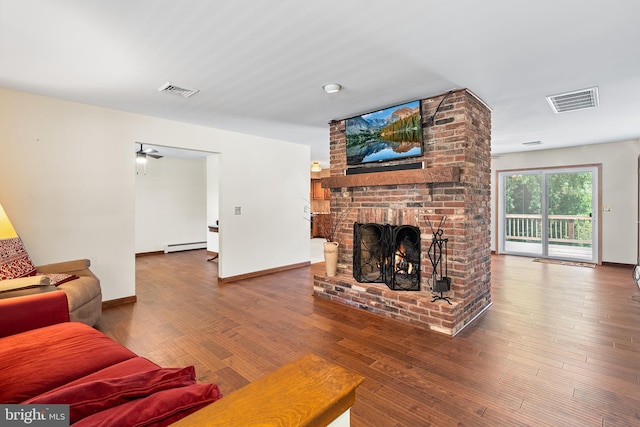 136 Main St, Red Hill, PA 18076 - living area with wood finished floors, a baseboard radiator, and a brick fireplace