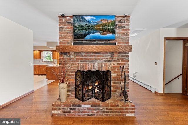 136 Main St, Red Hill, PA 18076 - detailed view of a baseboard heating unit, wood finished floors, and a fireplace