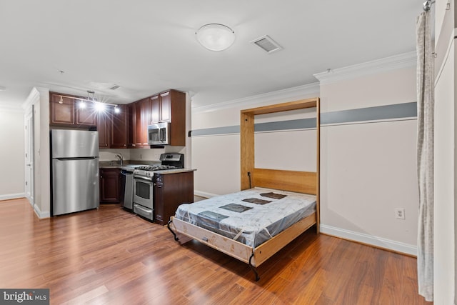 1210 R St NW Unit B1, Washington, DC 20009 - kitchen featuring stainless steel appliances, ornamental molding, light countertops, light wood-style floors, and dark brown cabinets