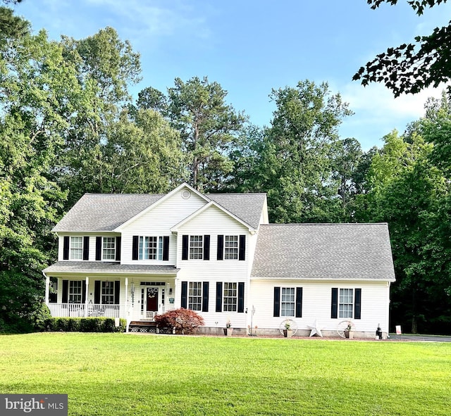 21481 Indian Bridge Rd, California, MD 20619 - colonial inspired home featuring covered porch, a front yard, a shingled roof, and view of scattered trees