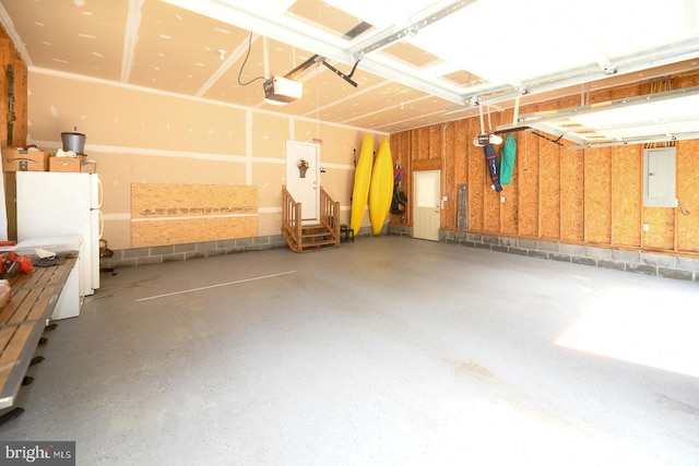 21481 Indian Bridge Rd, California, MD 20619 - garage with electric panel, a garage door opener, and freestanding refrigerator